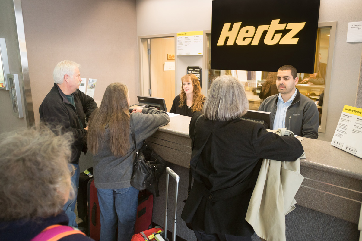 Image of passengers standing at the Hertz counter at Pangborn Memorial Airport